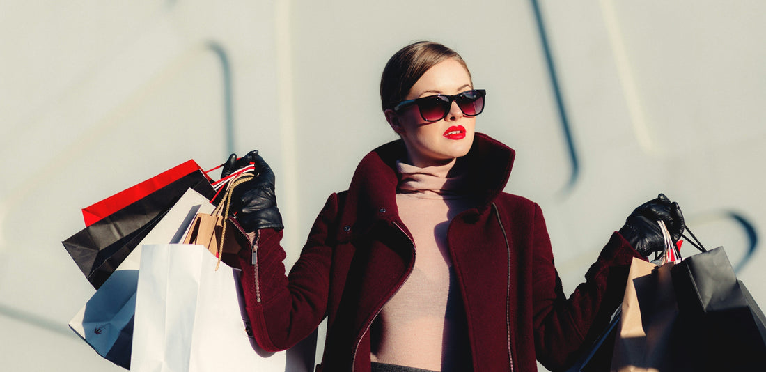 Mulher com vários sacos de compras, representando o consumo impulsivo associado ao fast fashion