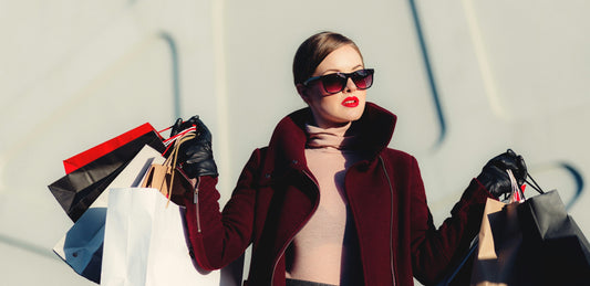 Mulher com vários sacos de compras, representando o consumo impulsivo associado ao fast fashion